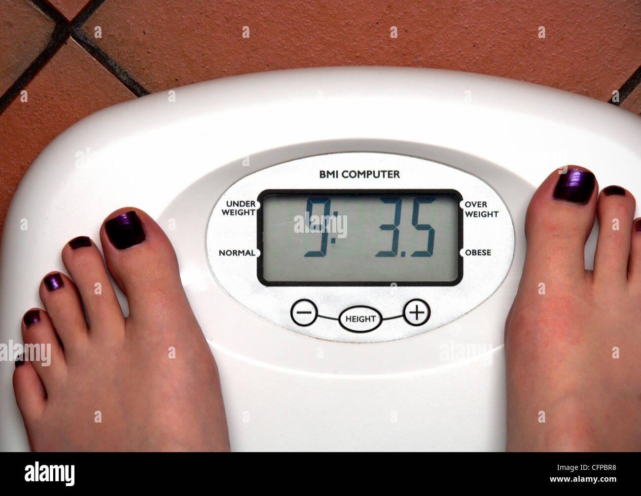Young woman with feet on bathroom scales Stock Photo Alamy