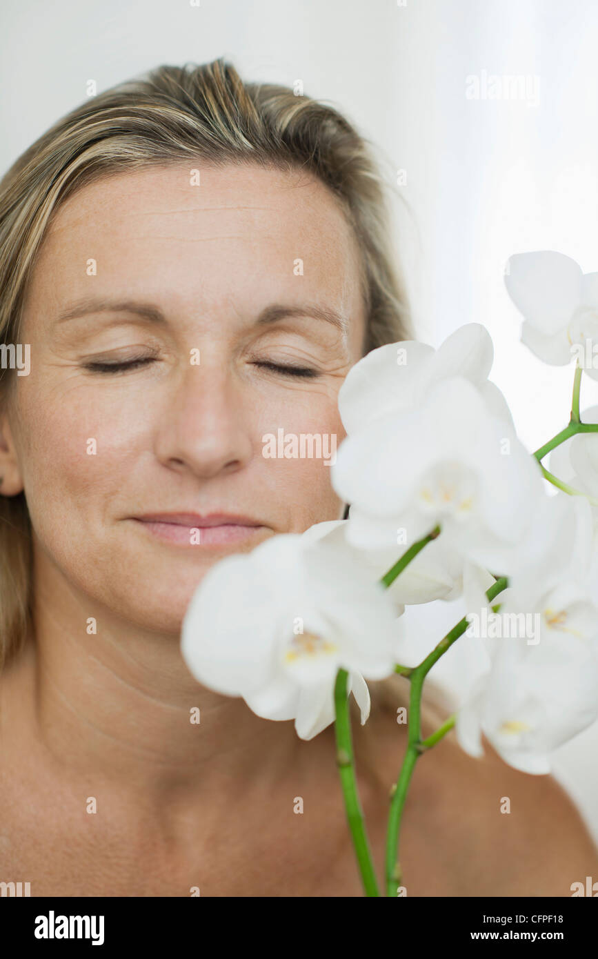 Woman smelling flowers, eyes closed Stock Photo - Alamy