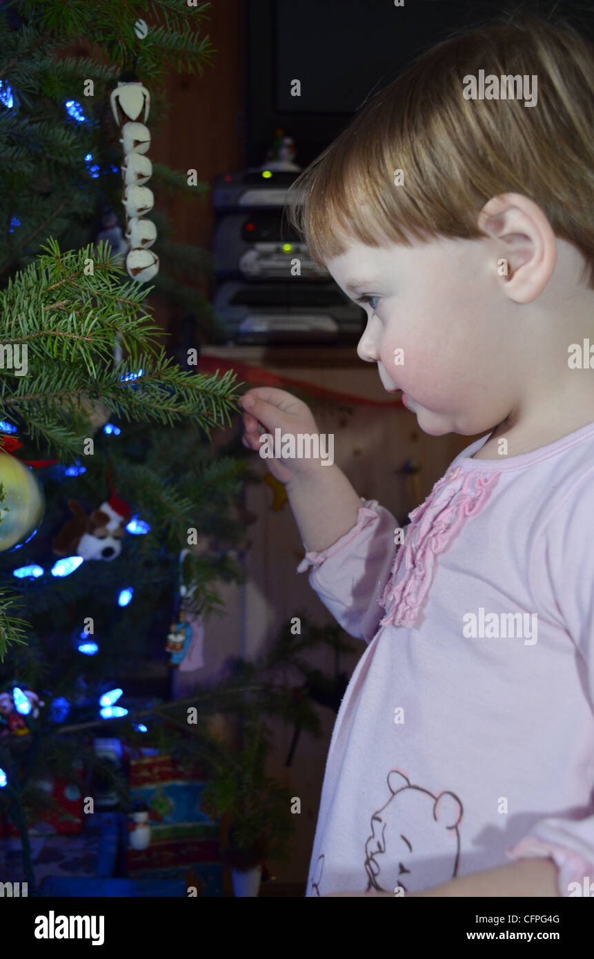 A little girl looking at the Christmas tree. Stock Photo
