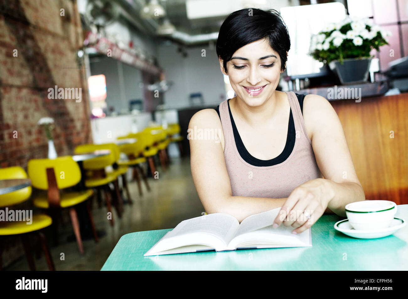 Woman Reading Book In Restaurant Stock Photo Alamy