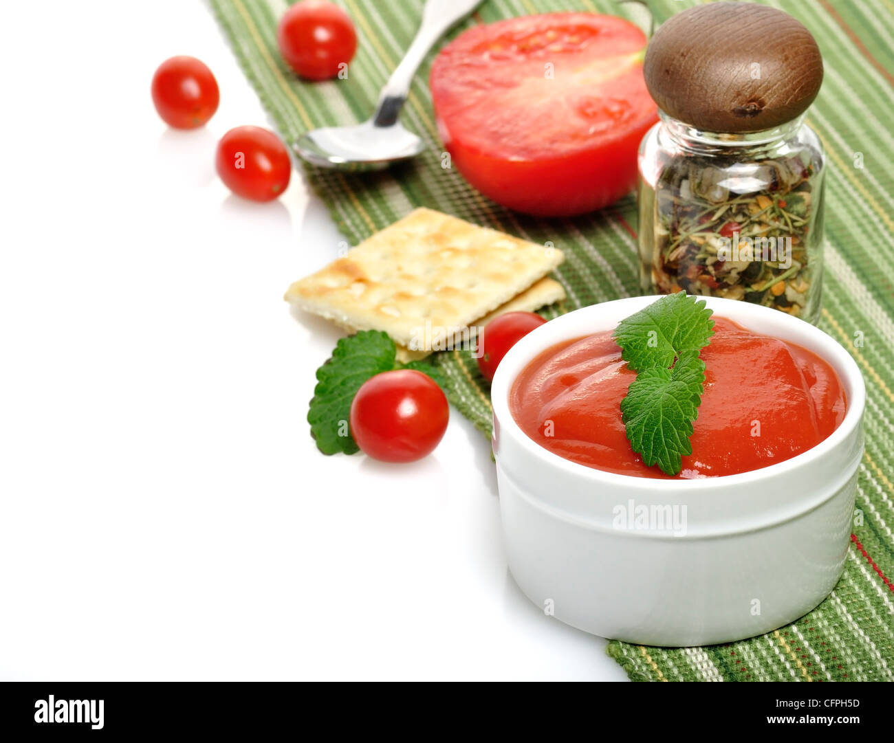 Tomato Soup In A White Bowl With Cracker And Spices Stock Photo