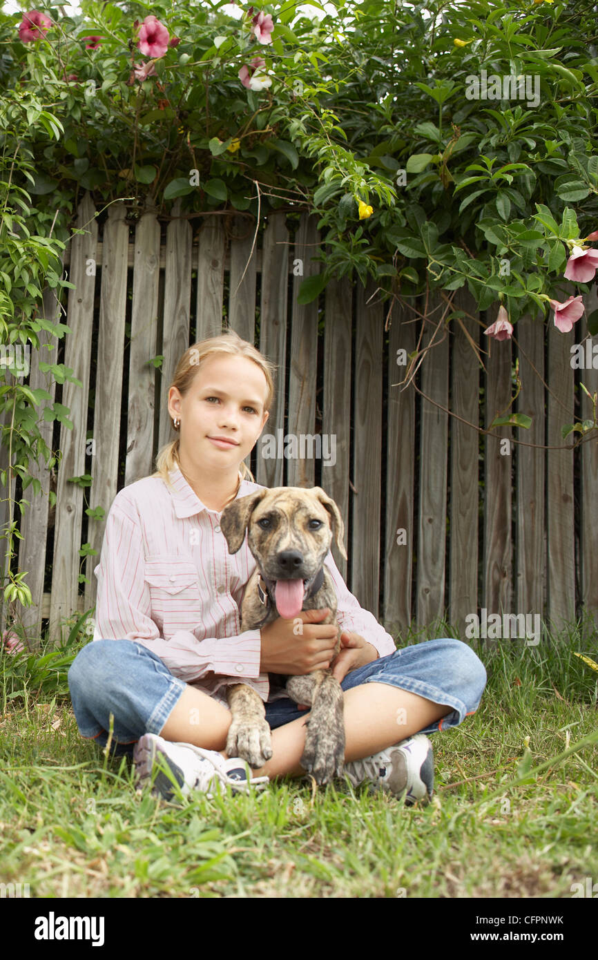 Young Girl Sitting on Lawn with Dog Stock Photo - Alamy