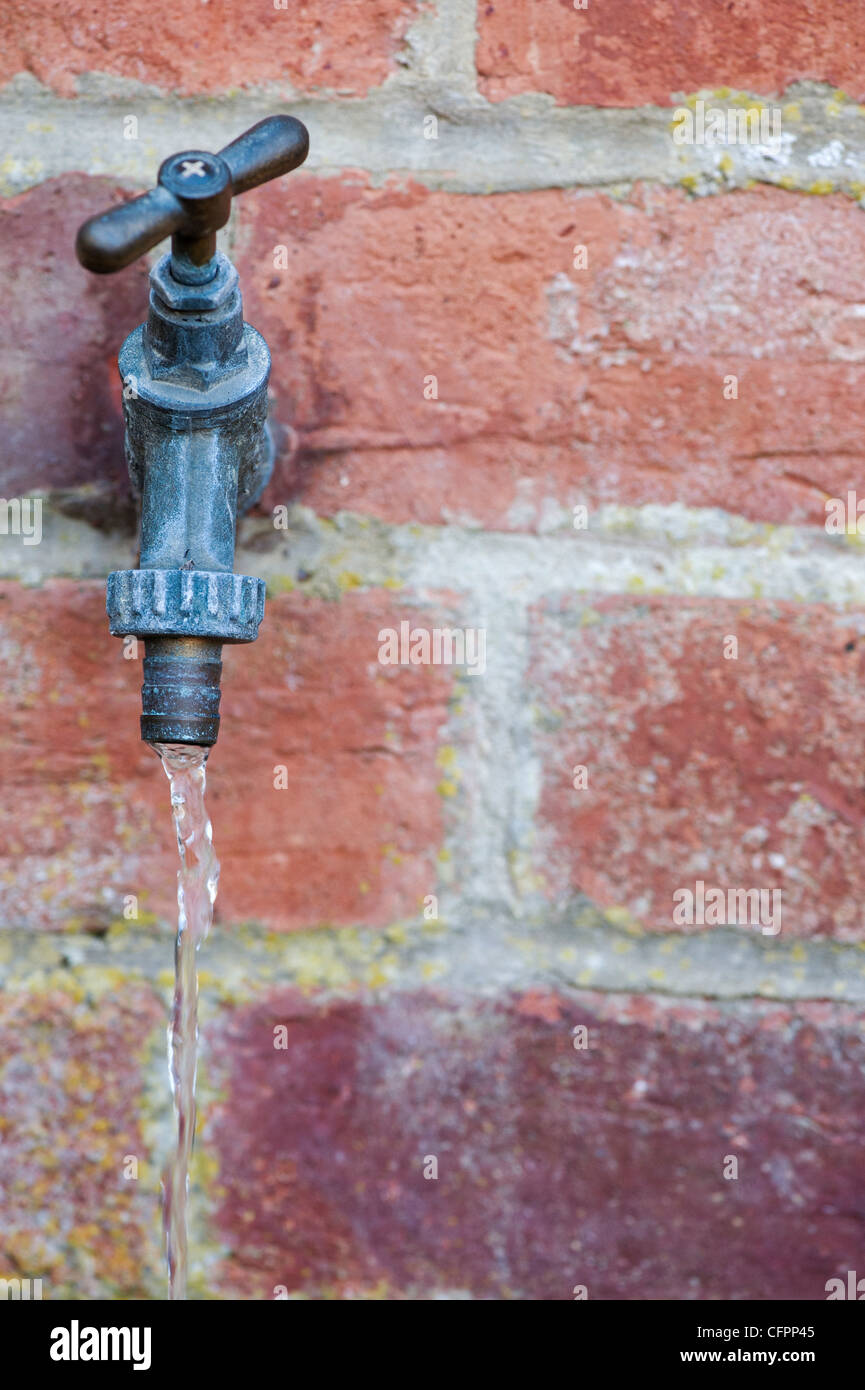 Running water coming from an outside garden water tap. UK Stock Photo