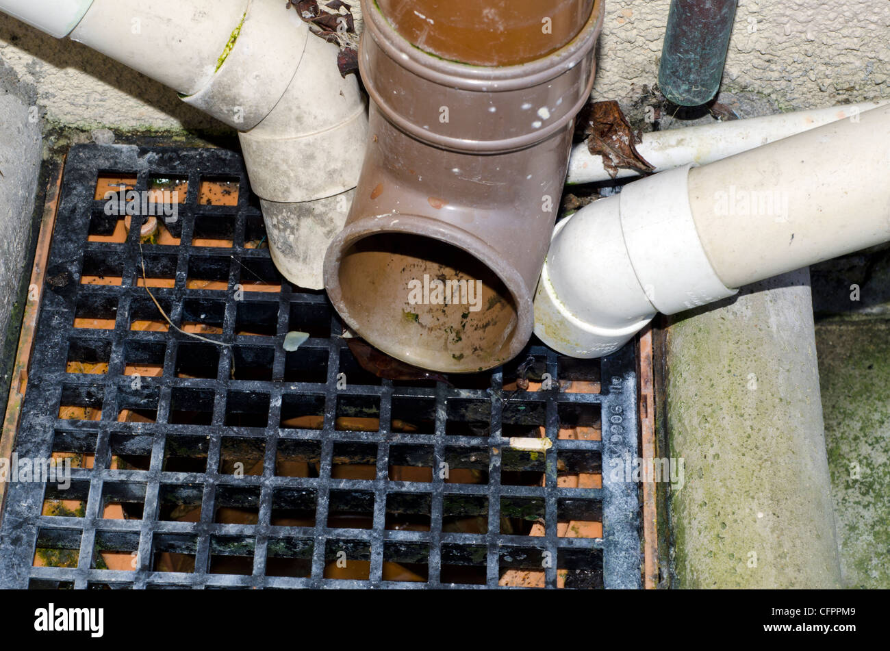 Outdoor drain with downpipes flowing into it. Stock Photo