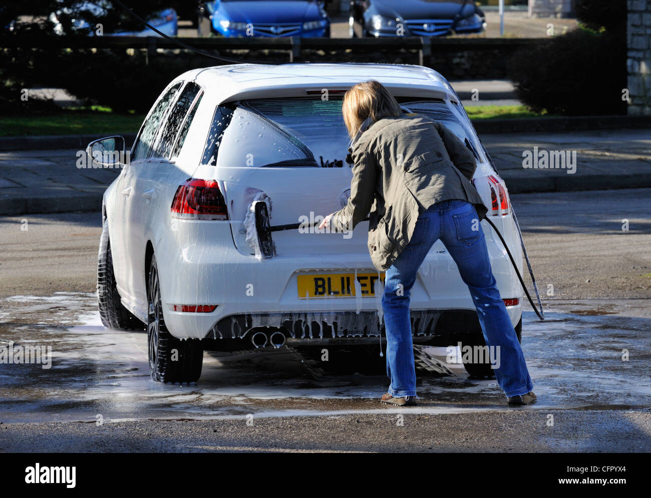 Female motorist using manual car wash. Morrisons Supermarket, Kendal