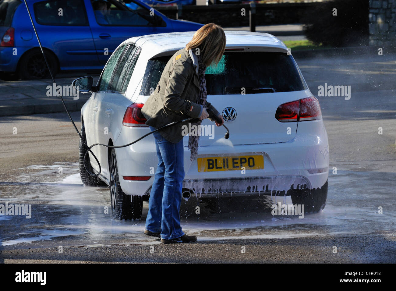 Female motorist using manual car wash. Morrisons Supermarket, Kendal