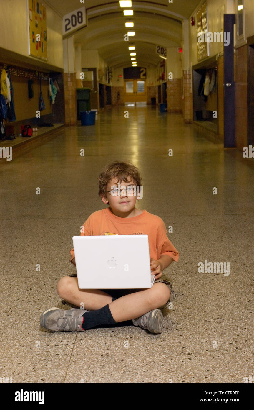 Boy Sitting in Hallway with Laptop Stock Photo Alamy