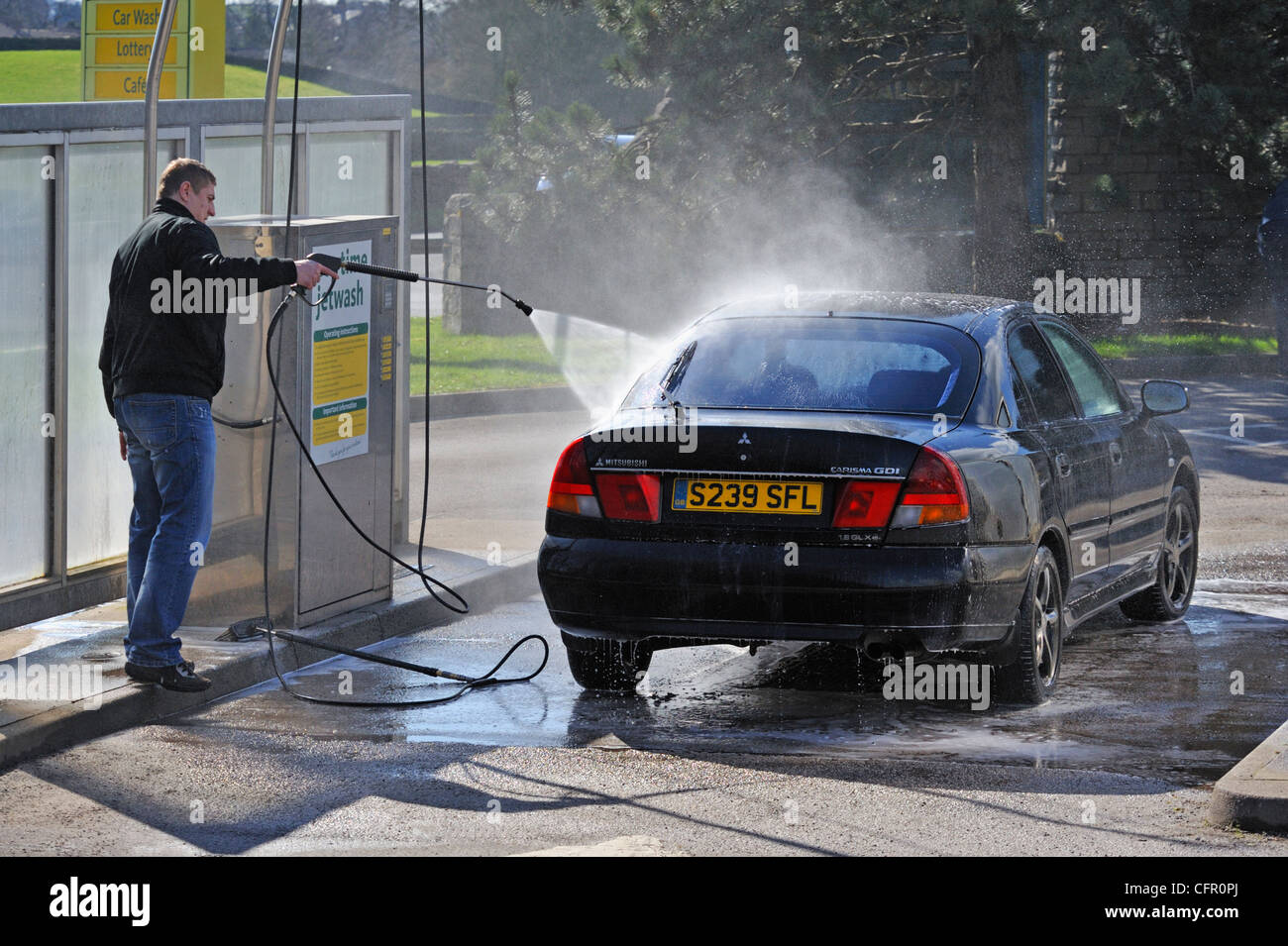 Male motorists using manual car wash. Morrisons Supermarket, Kendal