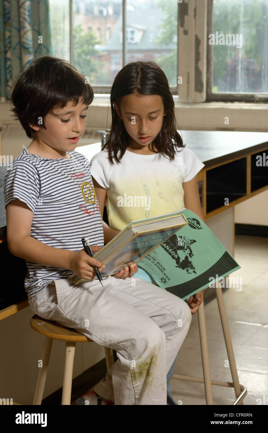 Boy and Girl in Classroom Reading Books Stock Photo - Alamy