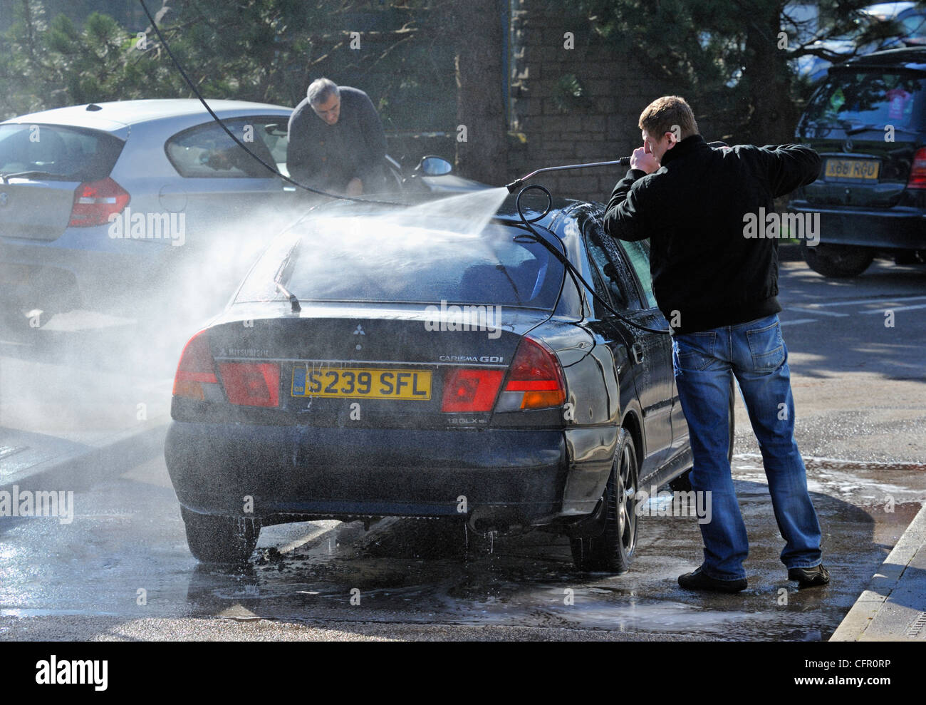 Male motorists using manual car wash. Morrisons Supermarket, Kendal