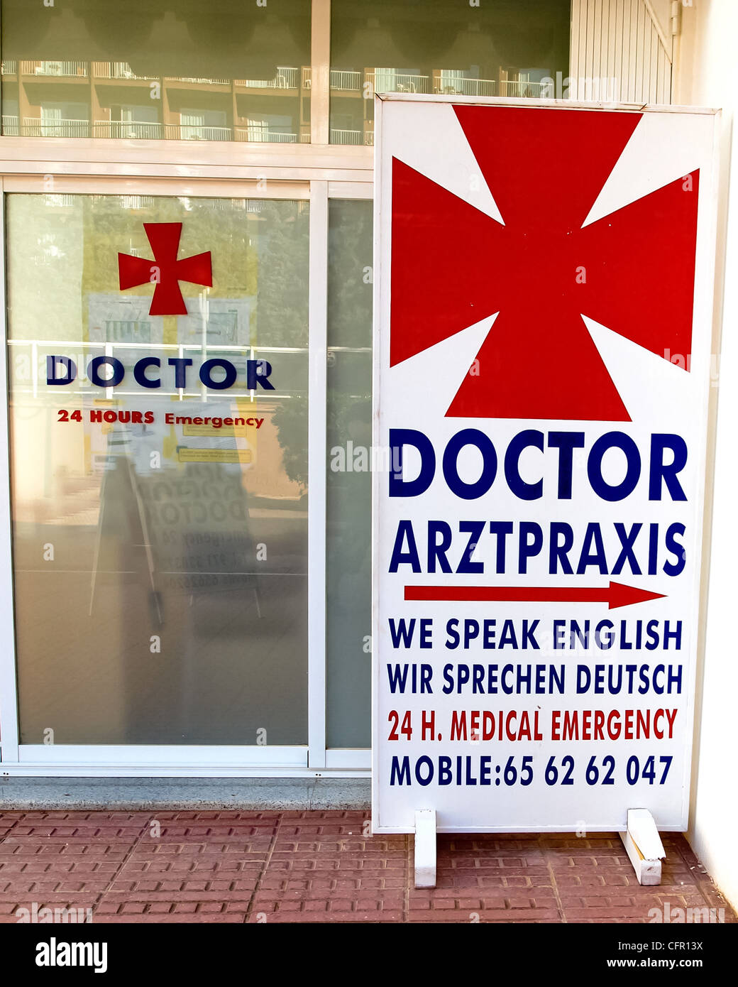 A doctors sign outside a surgery written in German and English Stock Photo