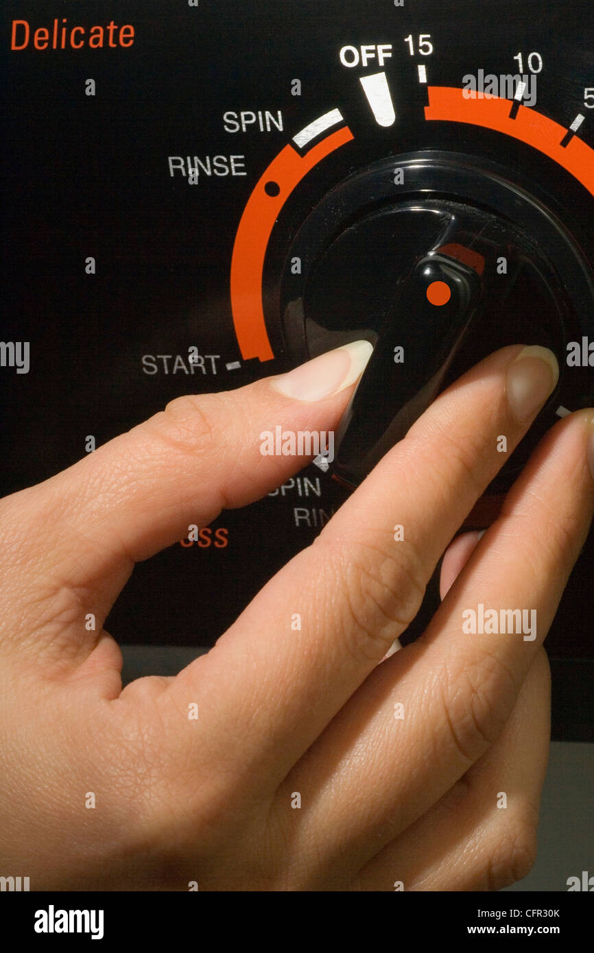 Hand Turning Knob on Washing Machine Stock Photo Alamy