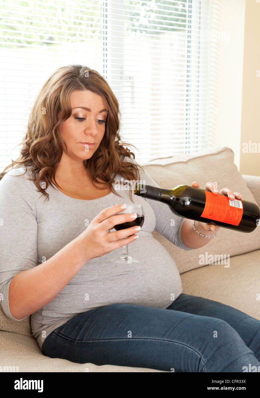 pregnant woman drinking a glass of wine Stock Photo