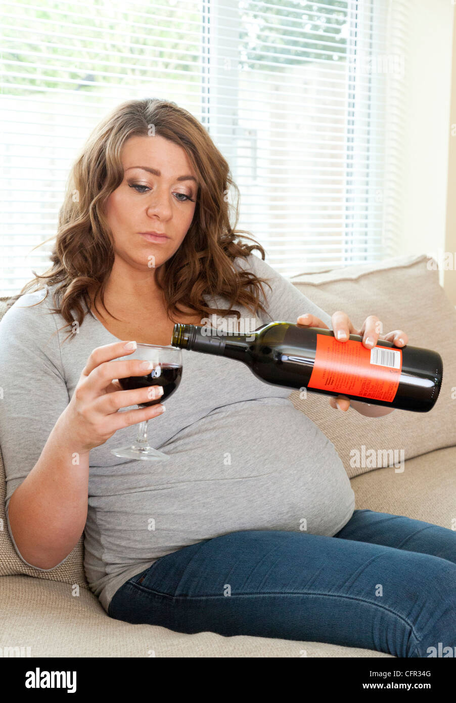 pregnant woman drinking a glass of wine Stock Photo