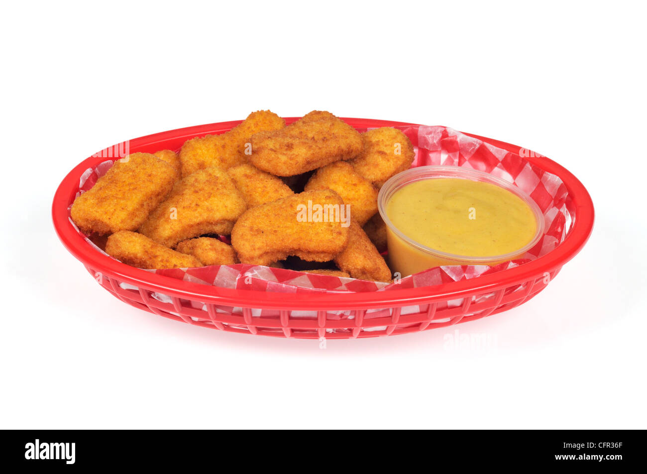 Chicken nuggets with honey mustard dipping sauce in plastic basket Stock Photo