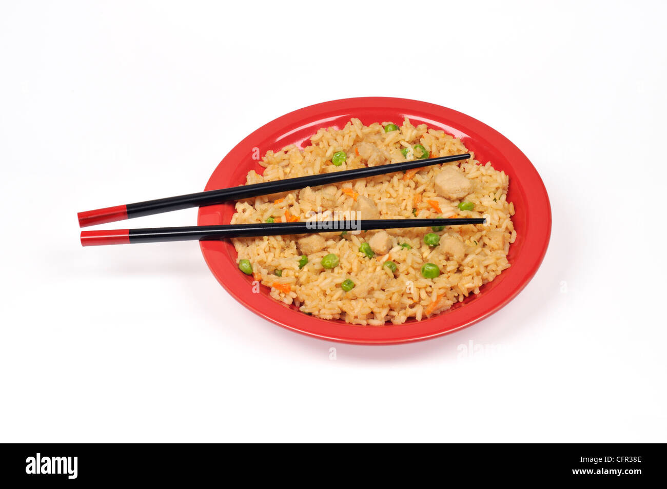 Oriental chicken fried rice with vegetables and chopsticks isolated on red plate Stock Photo