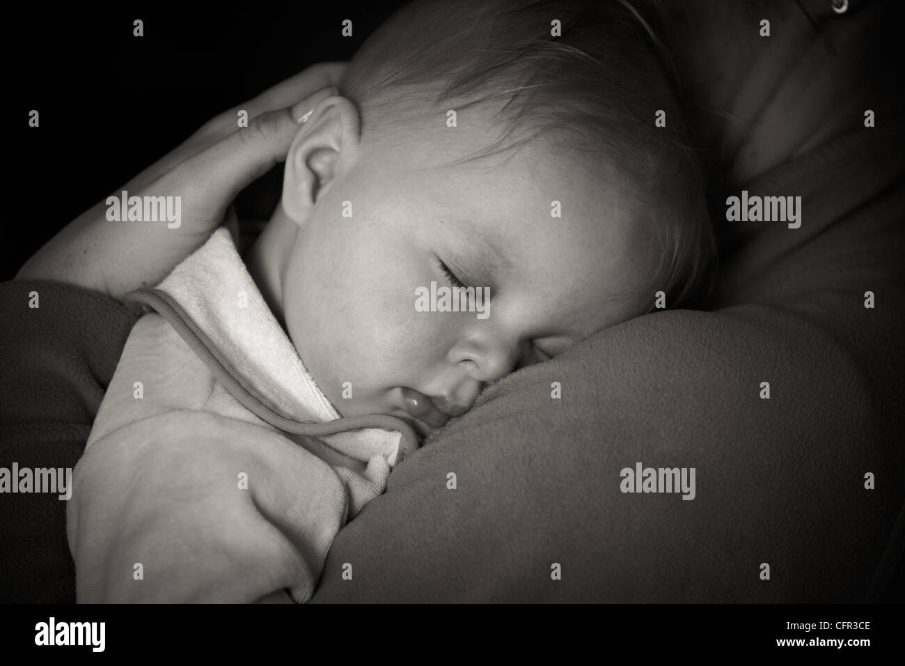 Sleeping infant in mothers arms Stock Photo Alamy