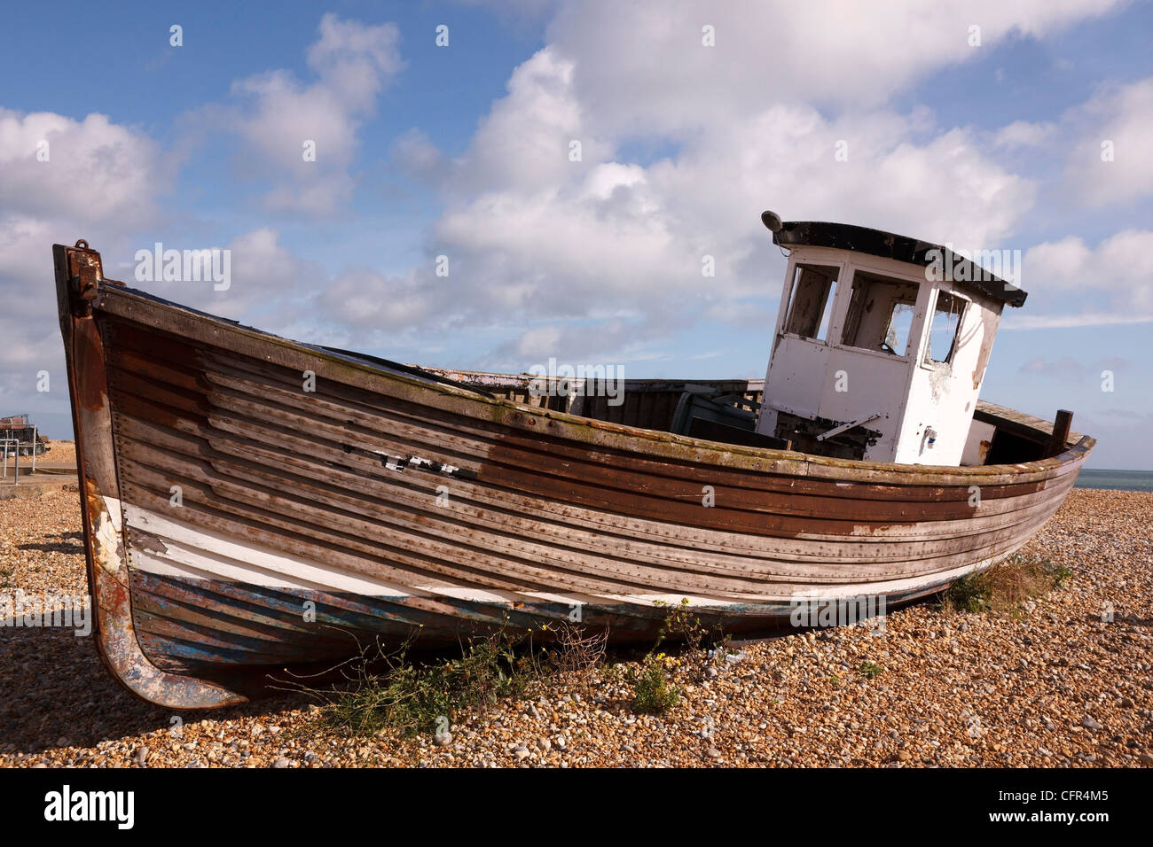 Old, clinker built, wooden fishing boat on shingle beach, Eastbourne, East Sussex, England, UK Stock Photo