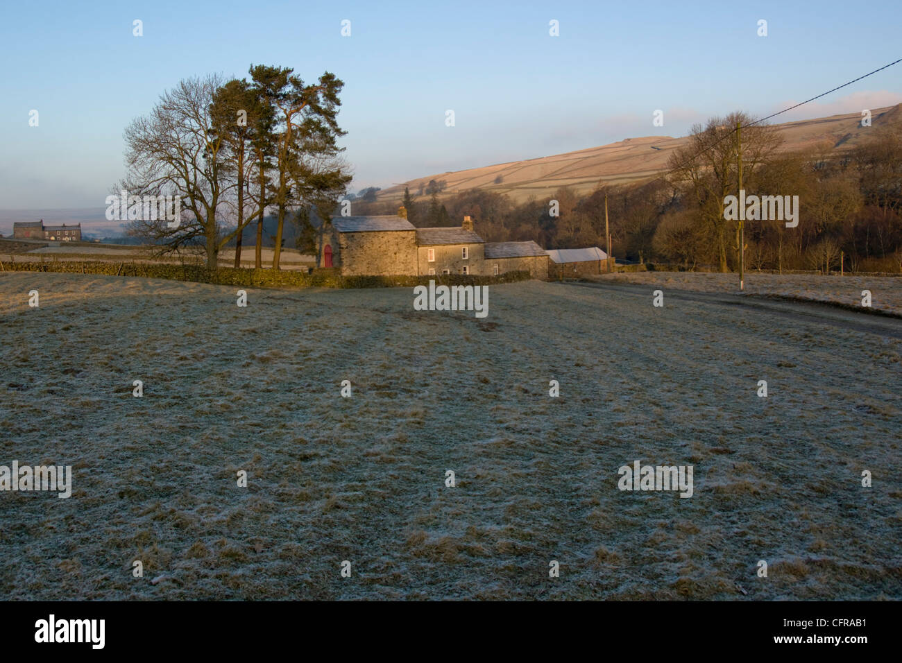 Frosty field leading to farmhouse and outbuildings in Pennines Stock Photo