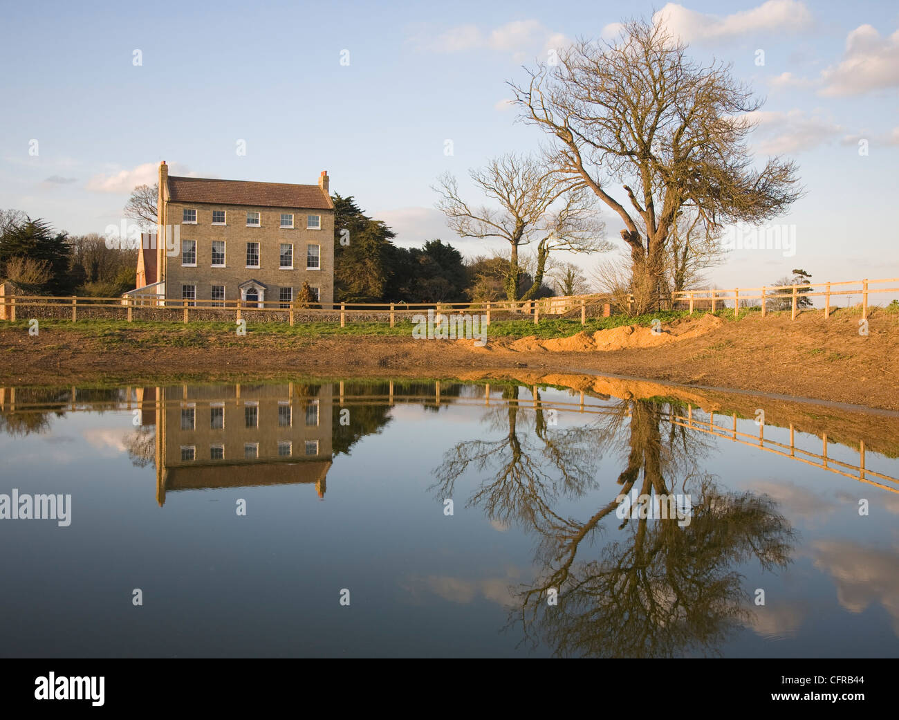Georgian farmhouse reflected in pond water Bawdsey, Suffolk, England Stock Photo