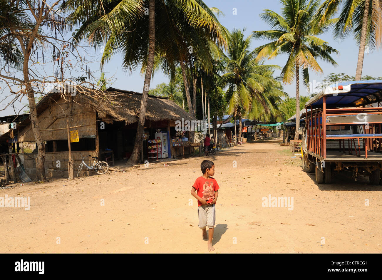 Lao boy walking through Don Det Village Si Phan Don Laos Stock Photo