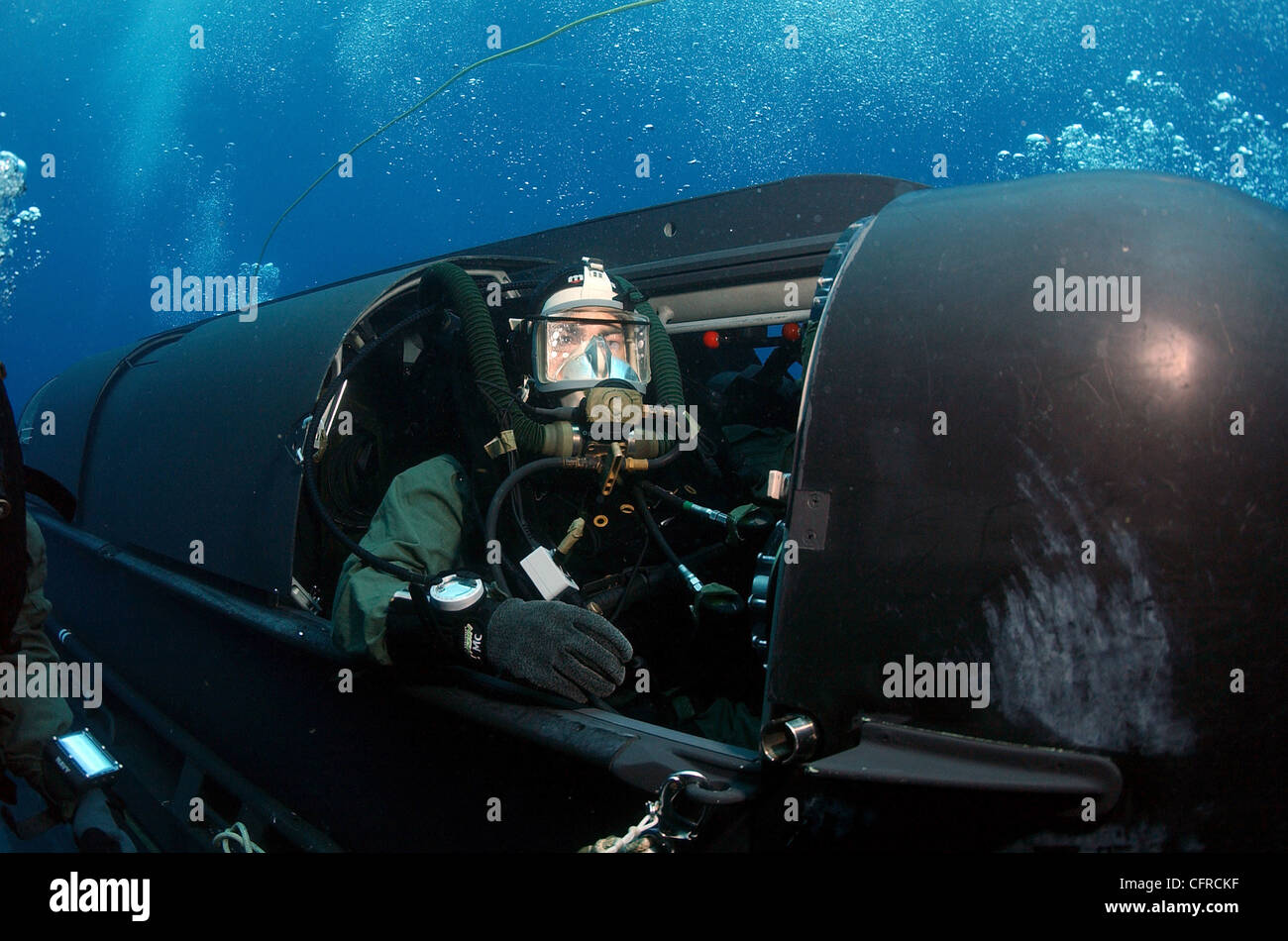 A member of SEAL Team Two climbs aboard a SEAL Delivery Vehicles before launching from the back of the attack submarine USS Philadelphia on a training exercise. The SDVs are used to carry Navy SEALs from a submerged submarine to enemy targets while staying underwater and undetected. Stock Photo