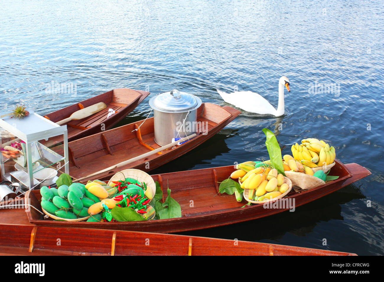 Swan and boats in a lake Stock Photo