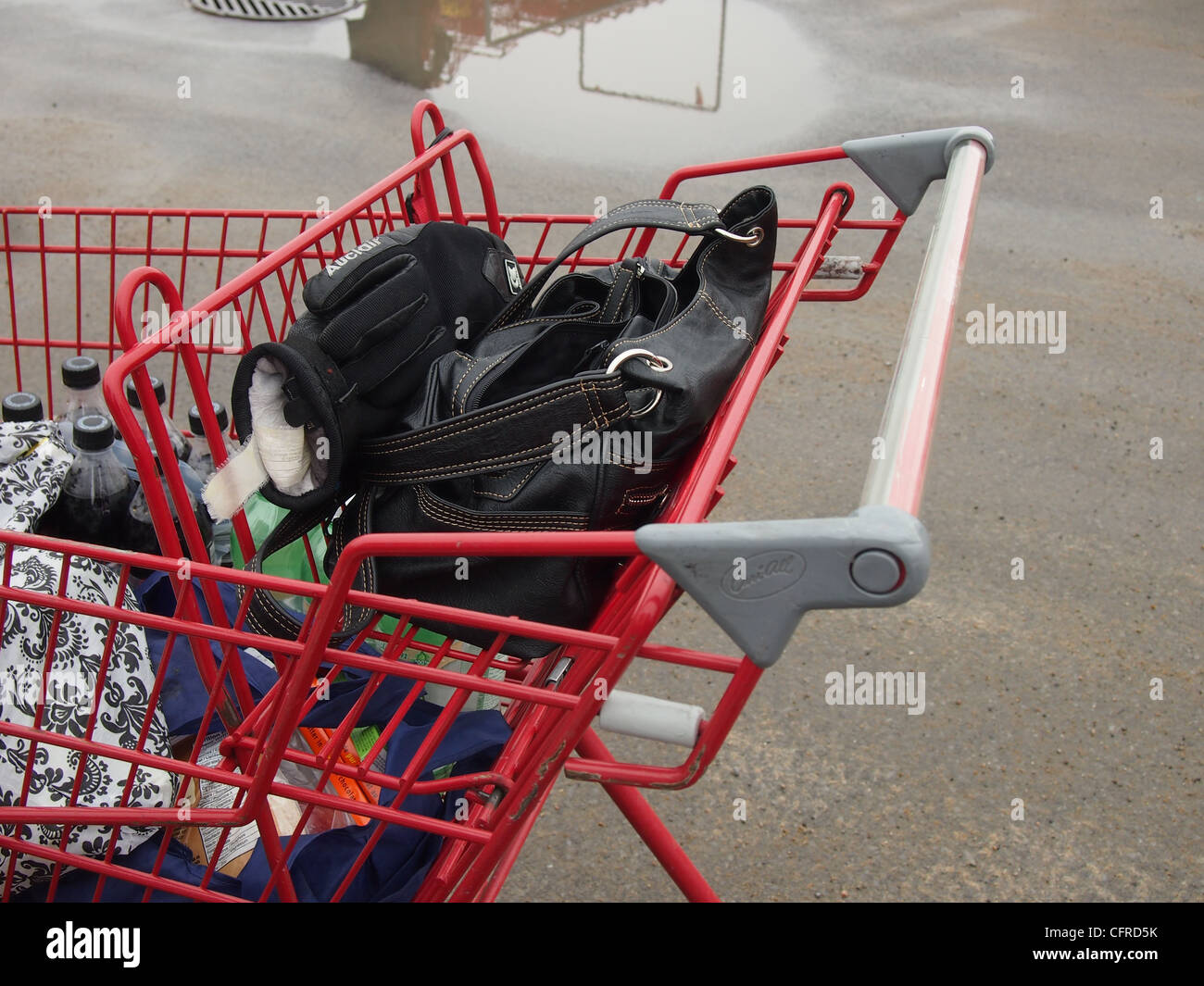 Grocery cart in parking lot with purse, gloves and shopping Stock Photo