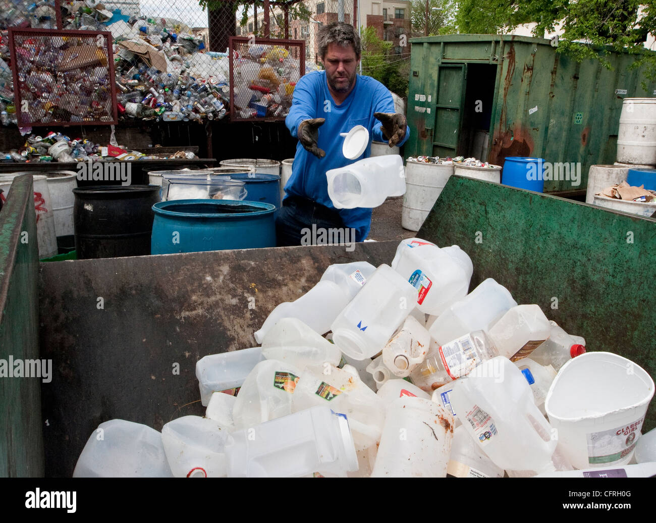 Workers sort through plastics at a recycling dropoff and processing