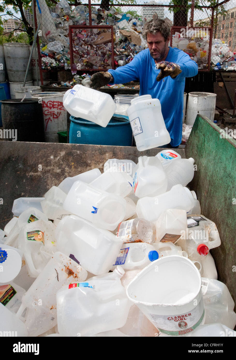 Workers sort through plastics at a recycling dropoff and processing