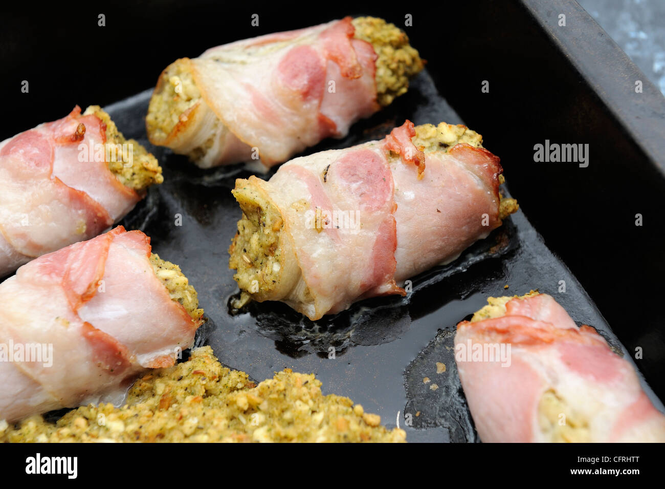bacon and stuffing rolls cooking in an over pan england uk Stock Photo Alamy