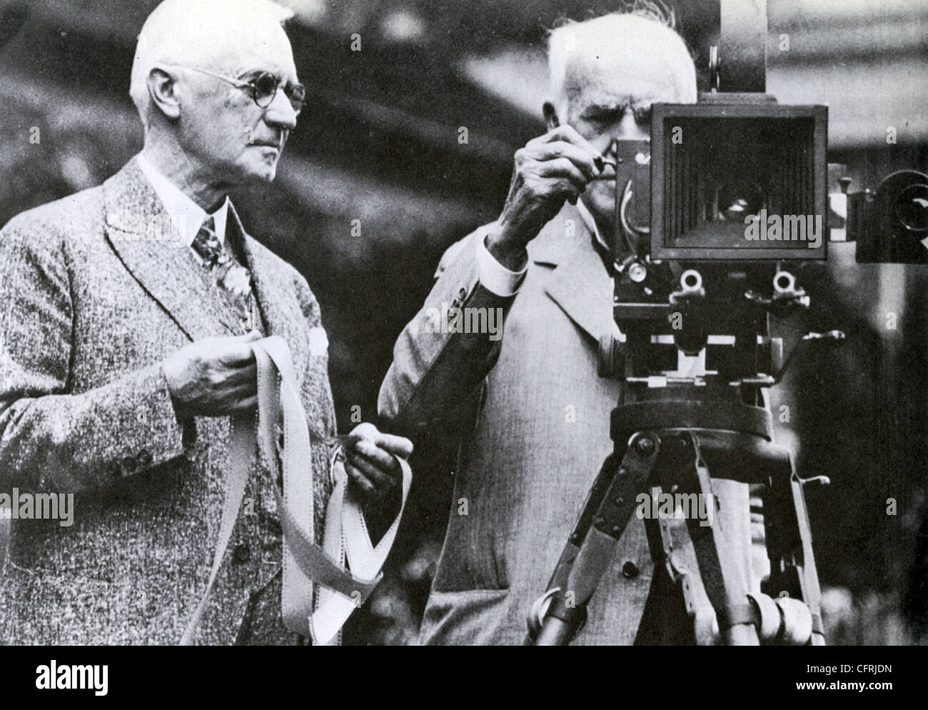 THOMAS EDISON at right demonstrating his movie camera to Kodak founder George Eastman in 1928 Stock Photo