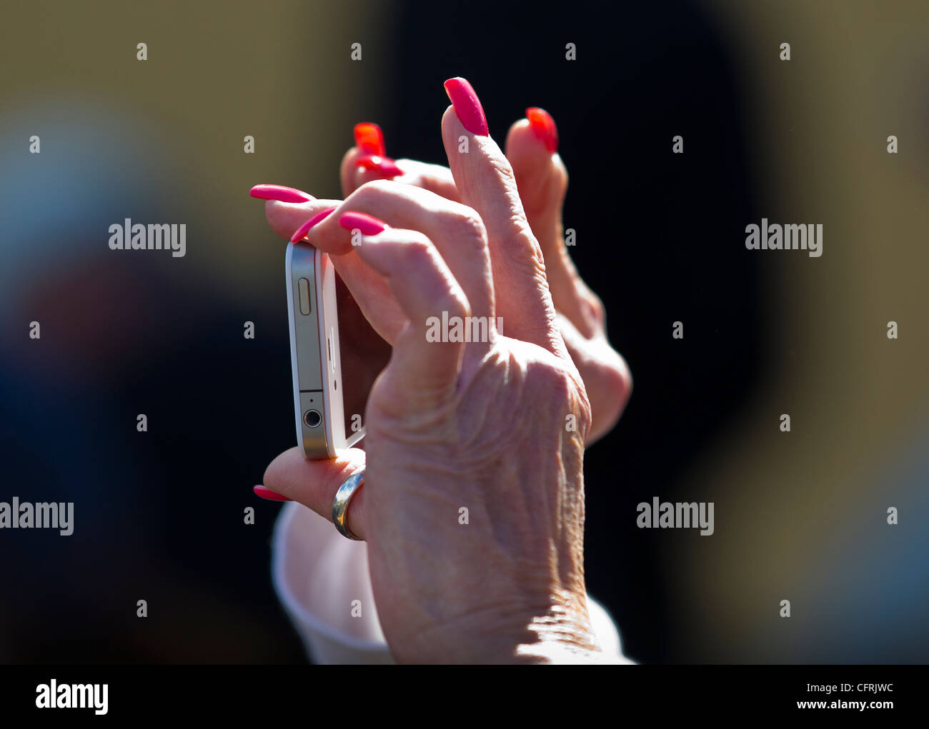Woman with long fingernails taking a photograph with an iPhone Stock Photo