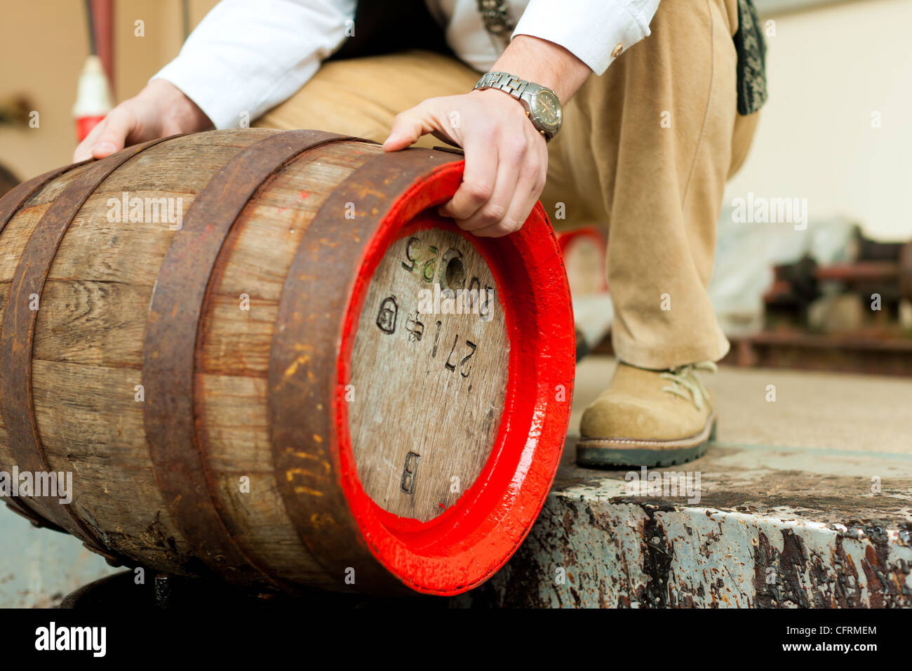 brewer in his brewery is traditionally sealing a beer barrel with tar