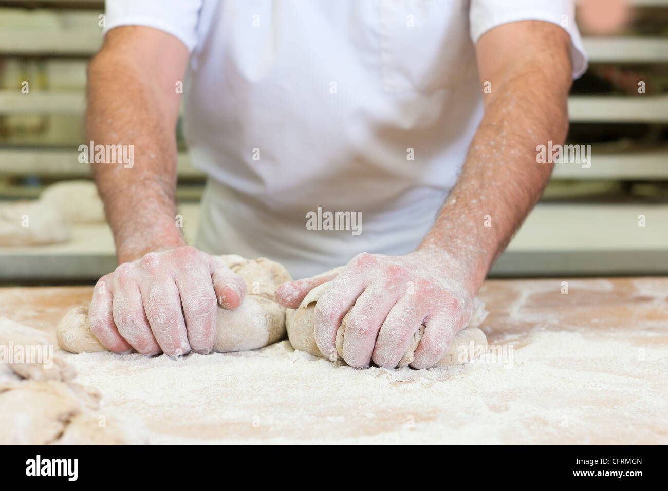Male baker baking fresh bread in the bakery Stock Photo