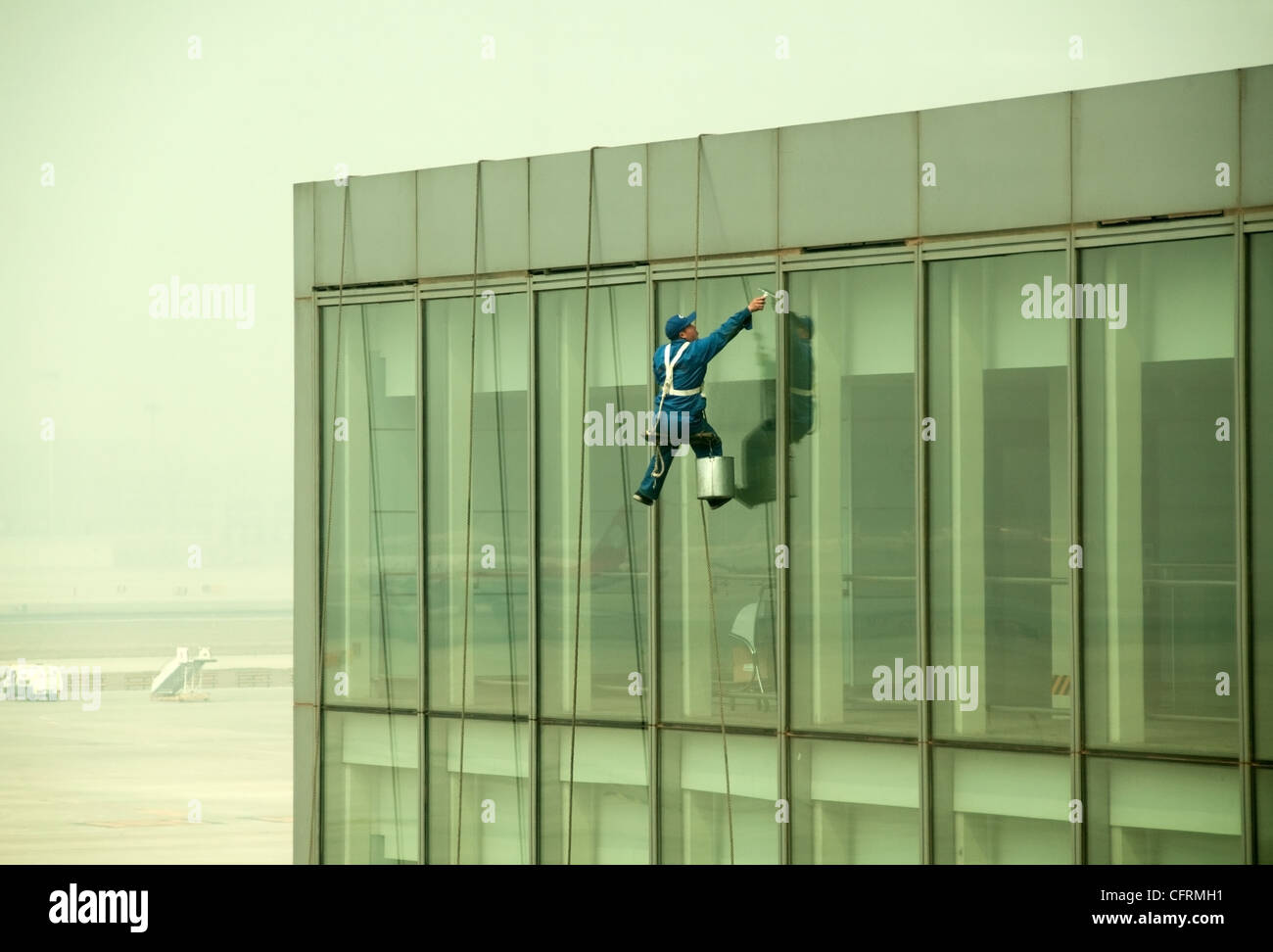 Hanging window cleaner at Beijing Airport, China Stock Photo