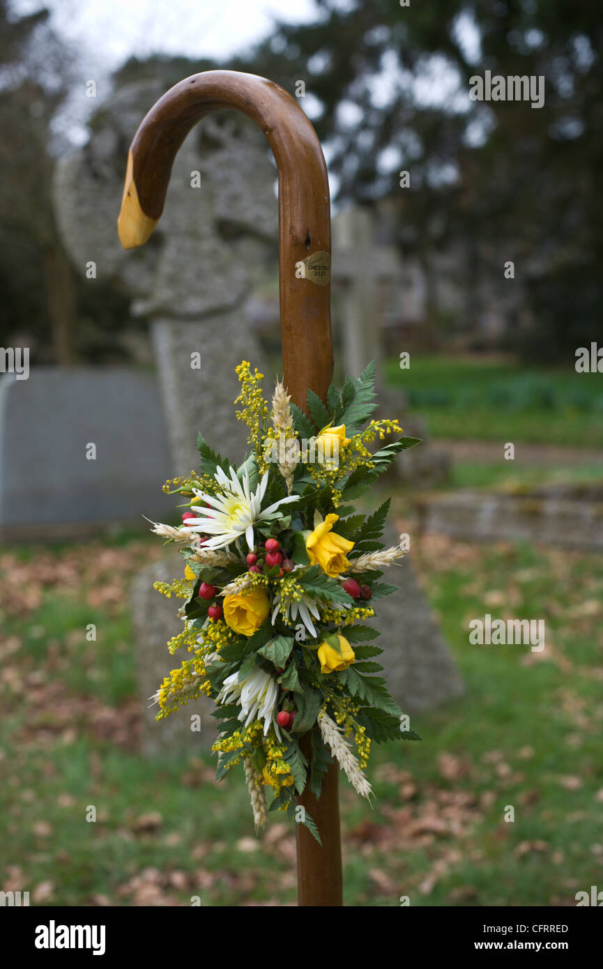 Shepherds crook with small wreath on burial in graveyard of rural St Mary's Church at Cusop Herefordshire England UK Stock Photo