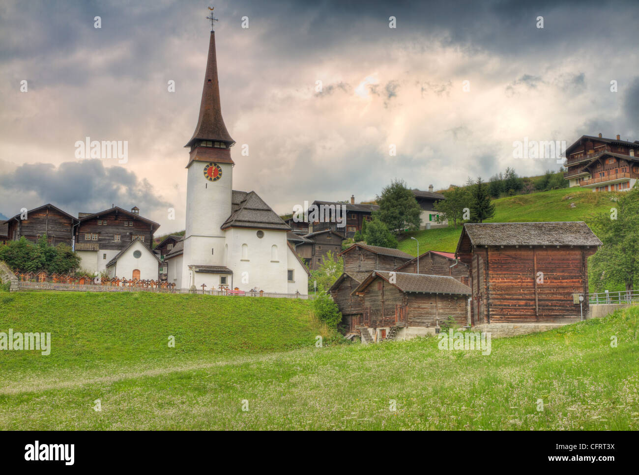small swiss village settlement of withered wooden houses and church in canton Valais Switzerland Stock Photo