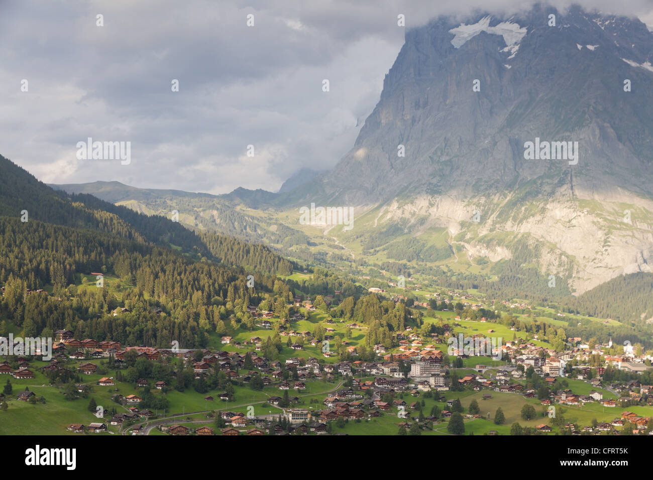 Famous alpine town Grindelwald in valley at sunset in front of mountain Eiger north face, Switzerland Stock Photo