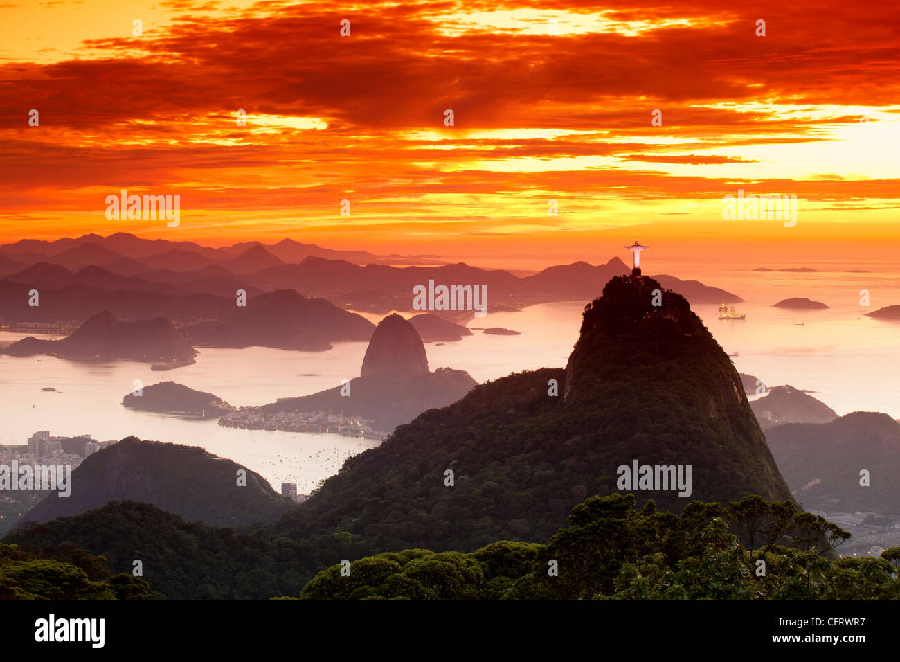 Sunrise at Christ, the Redeemer statue, Rio de Janeiro, Brazil. Sugar Loaf Mountain in the background. Brazil landmarks travel Stock Photo