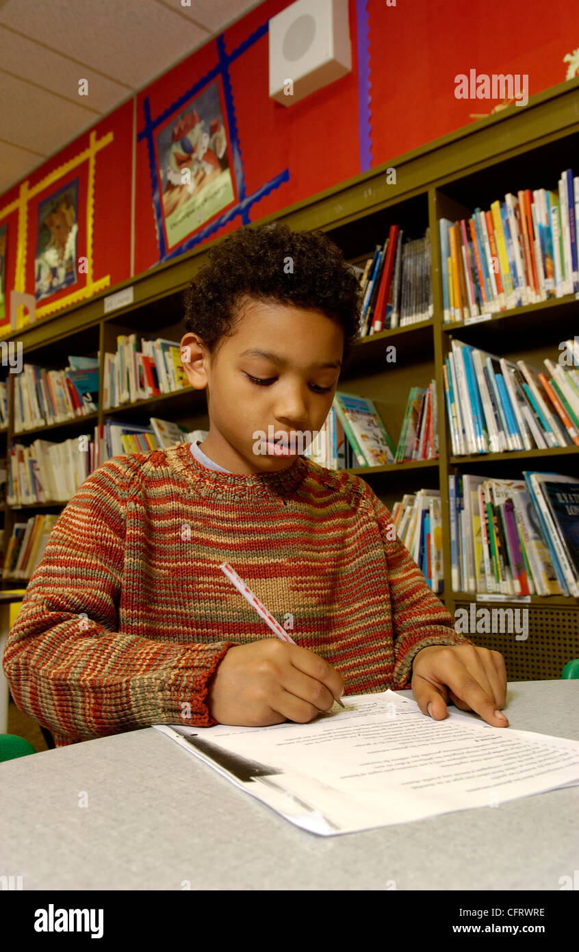 Eleven Year Old Boy Working  in School Library Stock Photo