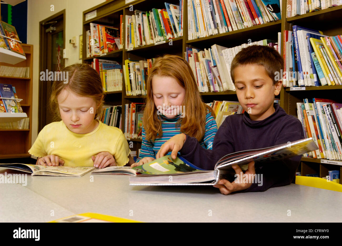 Eight Year Old Boy and Girls in School Library Stock Photo