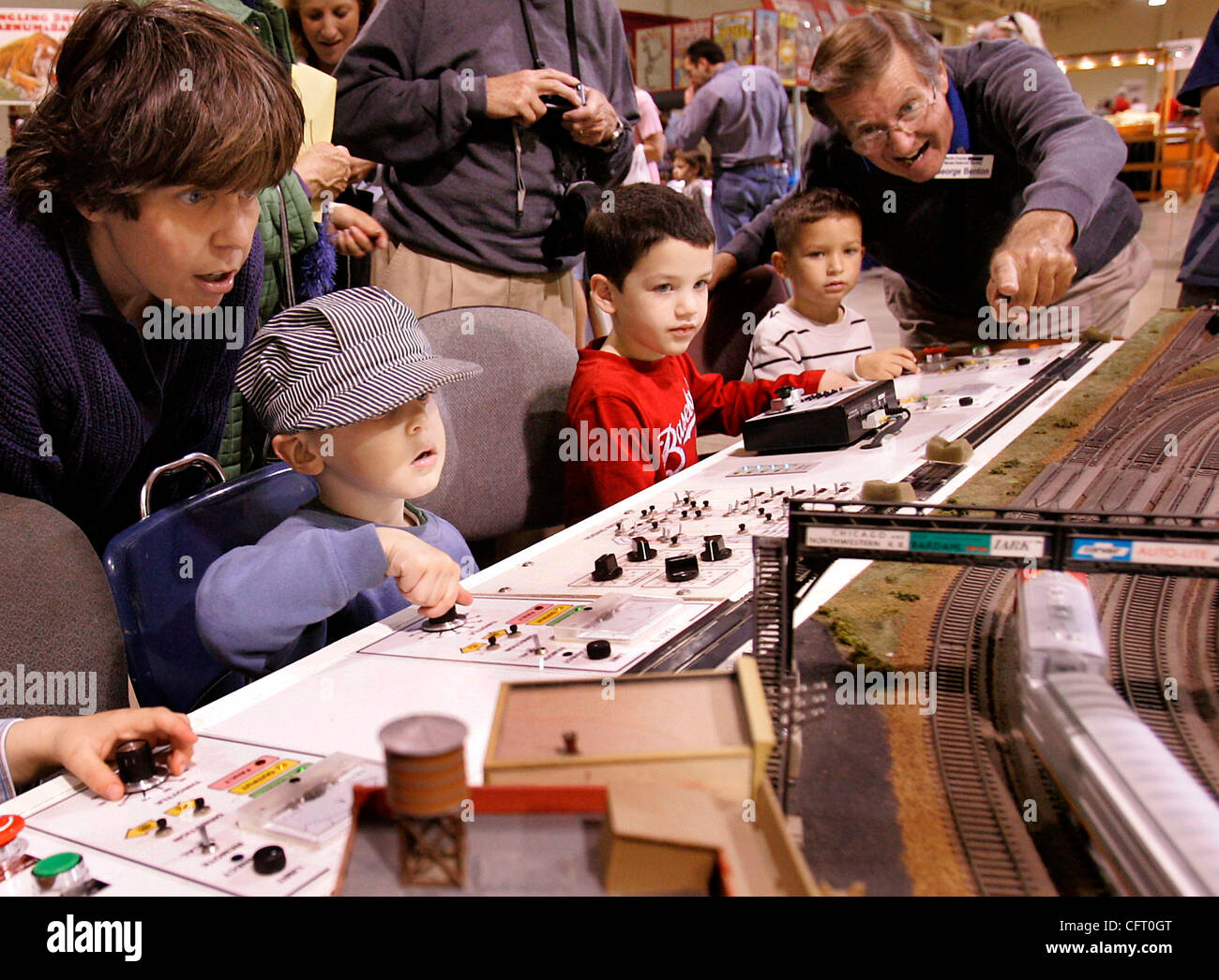 Saturday, December 2, 2006, Del Mar, California, USA Children receive little tips from George Benton, right, on how to handle the HO-Gage trains at the North County Model Railroad Society booth inside the Great Train Expo at the Del Mar Fairgrounds.  From left are Kevin Salazar, 3, of San Diego; Aar Stock Photo