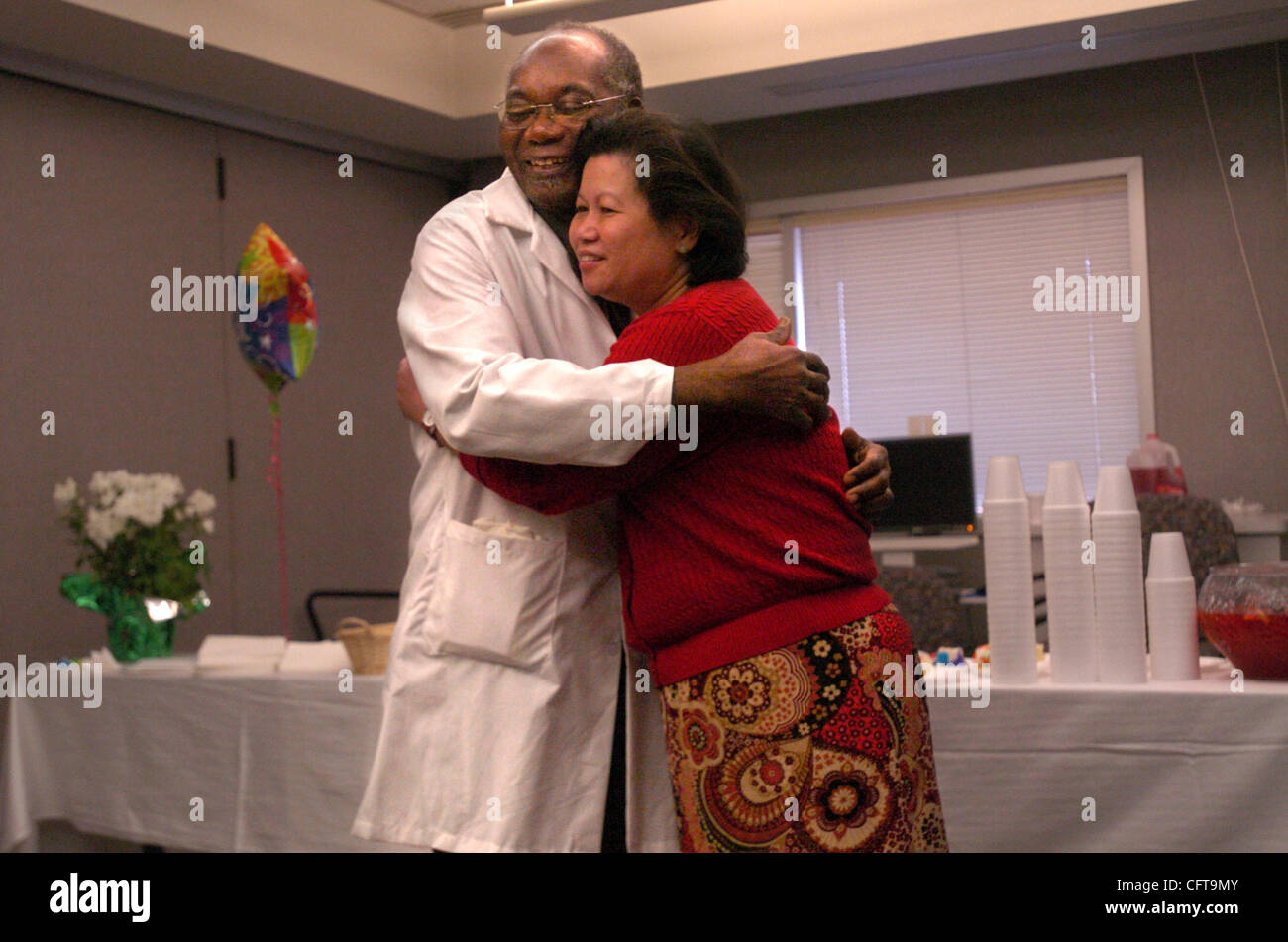 Dr. Camillus Udoffia, gets a warm embrace from Kaiser employee Betty Fong, on Tuesday, December 19, 2006 during a retirement party for his work as an OB/ GYN at Kaiser south. Dr. Udoffia is known for his sleight of hand in the delivery room and operating table. Dr. Udoffia, a Nigerian immigrant is b Stock Photo