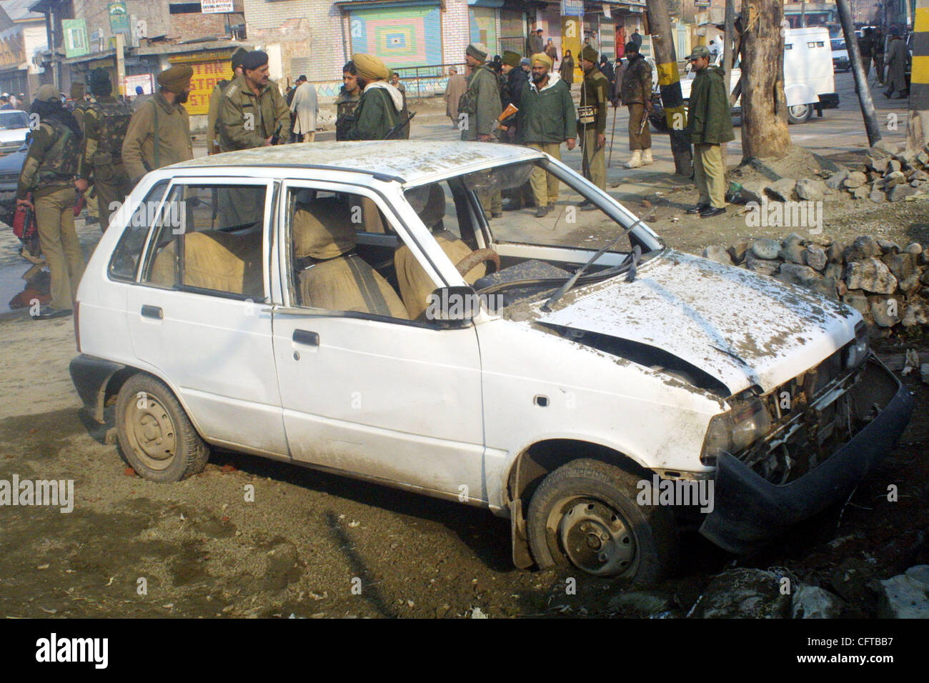 Indian security forces stand near a damaged car following an explosion in downtown area of Srinagar, the summer capital of Indian Kashmir, Friday, 29 December 2006. Shabir Hussain Khan, a Kashmiri civilian, who was riding a motorcycle, was killed on the spot when the Improvised Explosive Device (IED Stock Photo