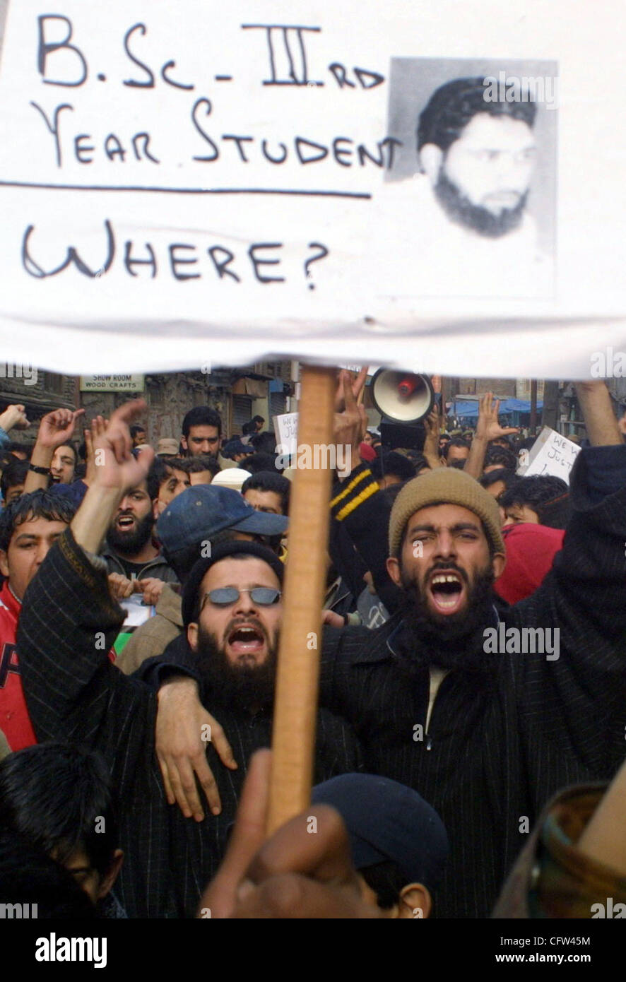Kashmiri protestors shout slogans as they hold a placard with pictures ...