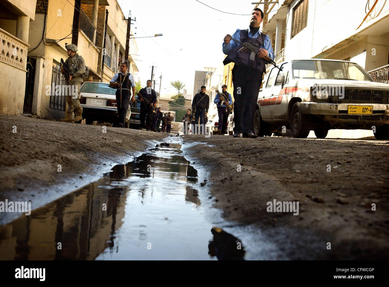 Feb 20, 2007 - Baghdad, Iraq - Iraq police officers and paratroopers, from the 82nd Airborne Division, walk down an alley as they do a joint patrol in the Al-Sulakh neighborhood. The 82nd's 2nd Brigade Combat Team was 'surged' into Baghdad last month as the Bush Administration unveiled its new strat Stock Photo
