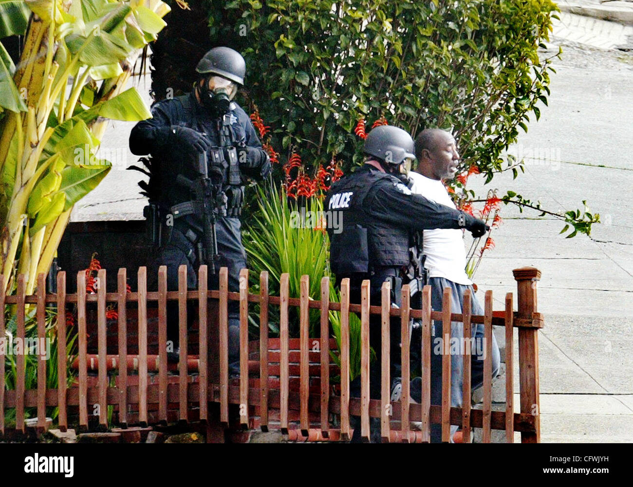 Members of the Oakland Police Department bring out a man who barricaded himself early Tuesday Feb, 27, 2007 on the 2800 block of Brookdale Avenue in Oakland, Calif. The police shot tear gas inside the house to force the entry and succesfully avoid injuries. (Ray Chavez/The Oakland Tribune) Stock Photo