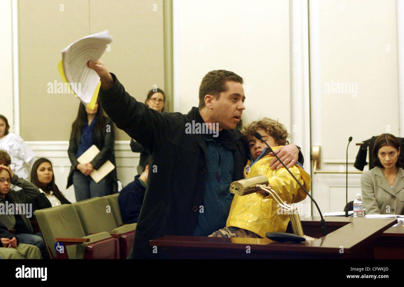 David Howard, holding his 3 yearold son Lawson, speaks to board