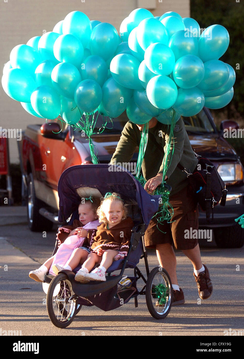 With his head buried in balloons, Trent Hugill pushes his twins Hannah